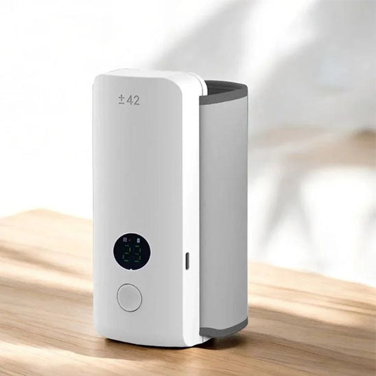 La photo présente un chauffe-biberon portable de couleur blanc.