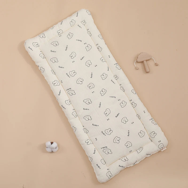 La photo montre un coussin pour poussette avec des motifs de lapins.