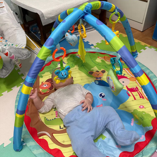 La photo montre un bébé sur son tapis d&