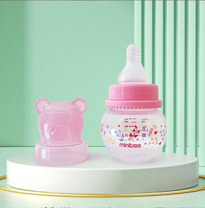 Baby bottles, specifically wide-bore PP bottles with bear-shaped caps, available in light-pink
