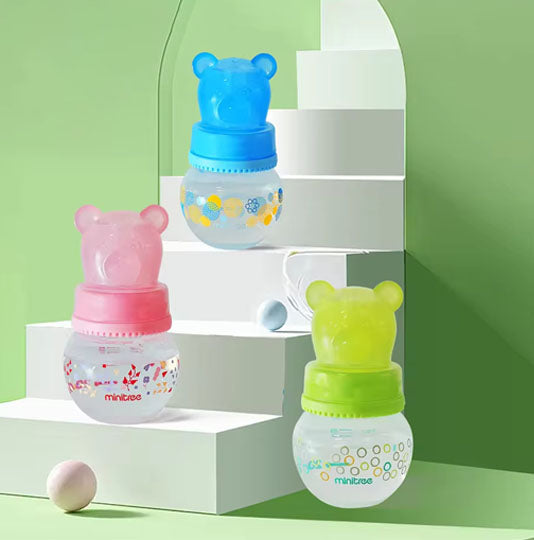 Baby bottles, specifically wide-bore PP bottles with bear-shaped caps, available in pink, green, and blue 
