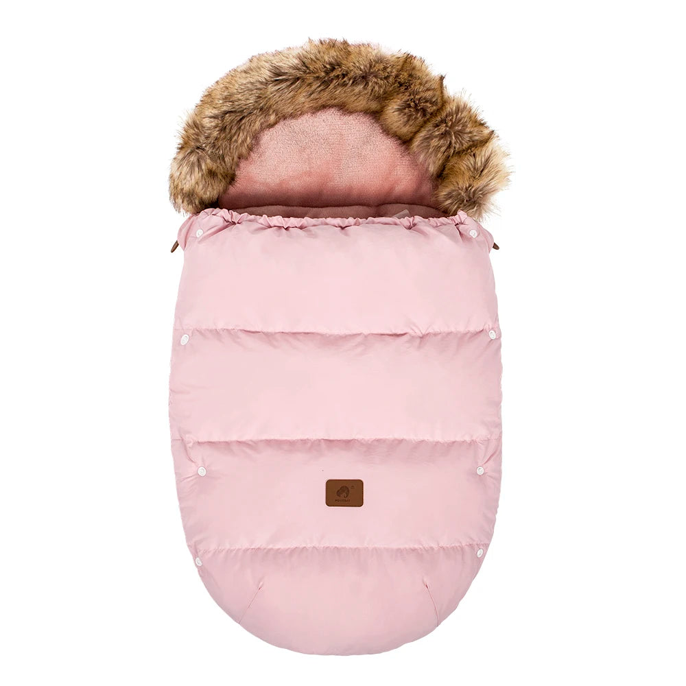 La photo montre une chancelière rose avec capuche en fourrure.