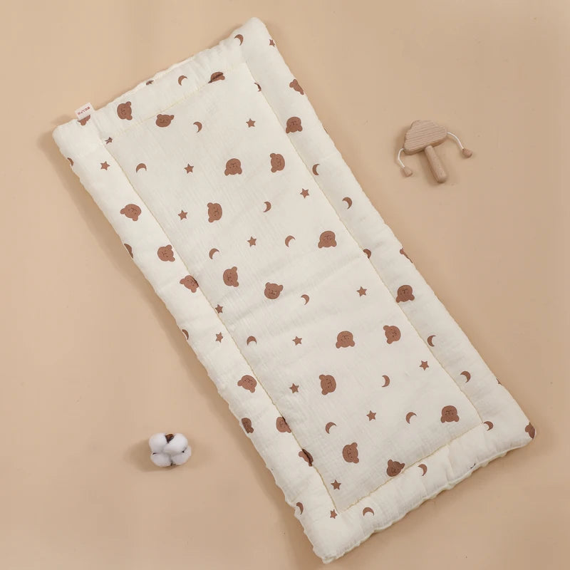 La photo montre un coussin pour poussette avec des motifs d'ours, d'étoiles et de lunes.