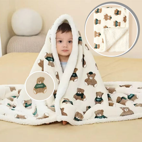 La photo montre un enfant recouvert de sa douce couverture aux motifs d&