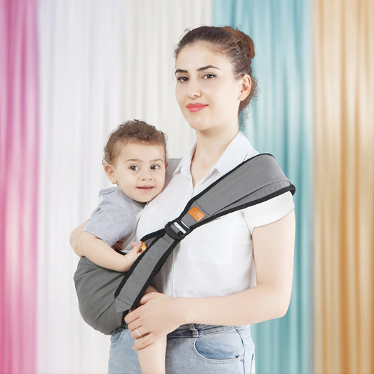 La photo montre une maman avec son enfant en bandoulière dans le porte bébé.