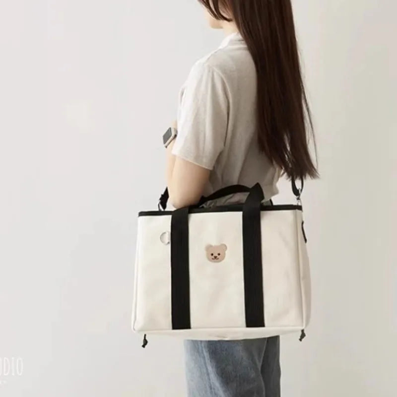 La photo montre une maman portant son sac à langer en bandoulière.