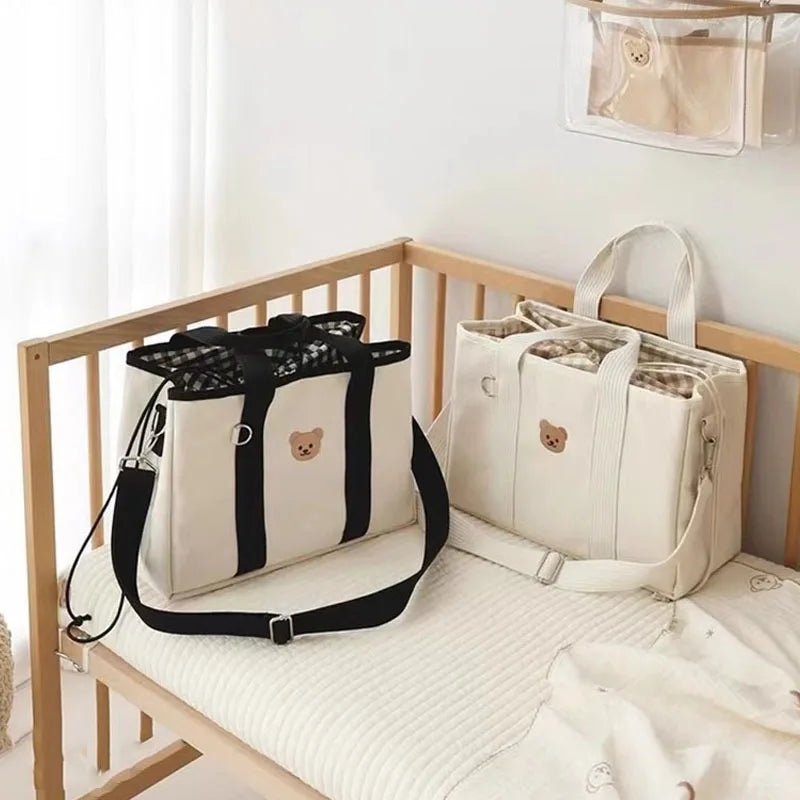 La photo montre deux modèles de sacs à langer posés sur un lit d'enfant.
