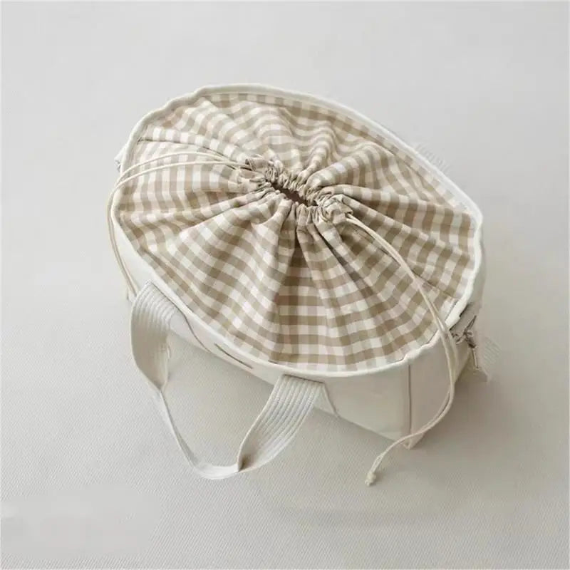 La photo montre un sac à langer plein et recouvert d'un tissu assorti pour cacher l'intérieur.