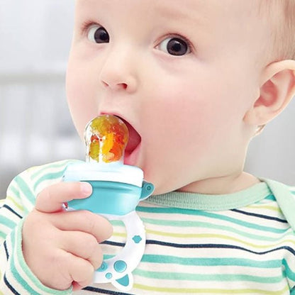 La photo montre un bébé avec une tétine à fruits dans la bouche.